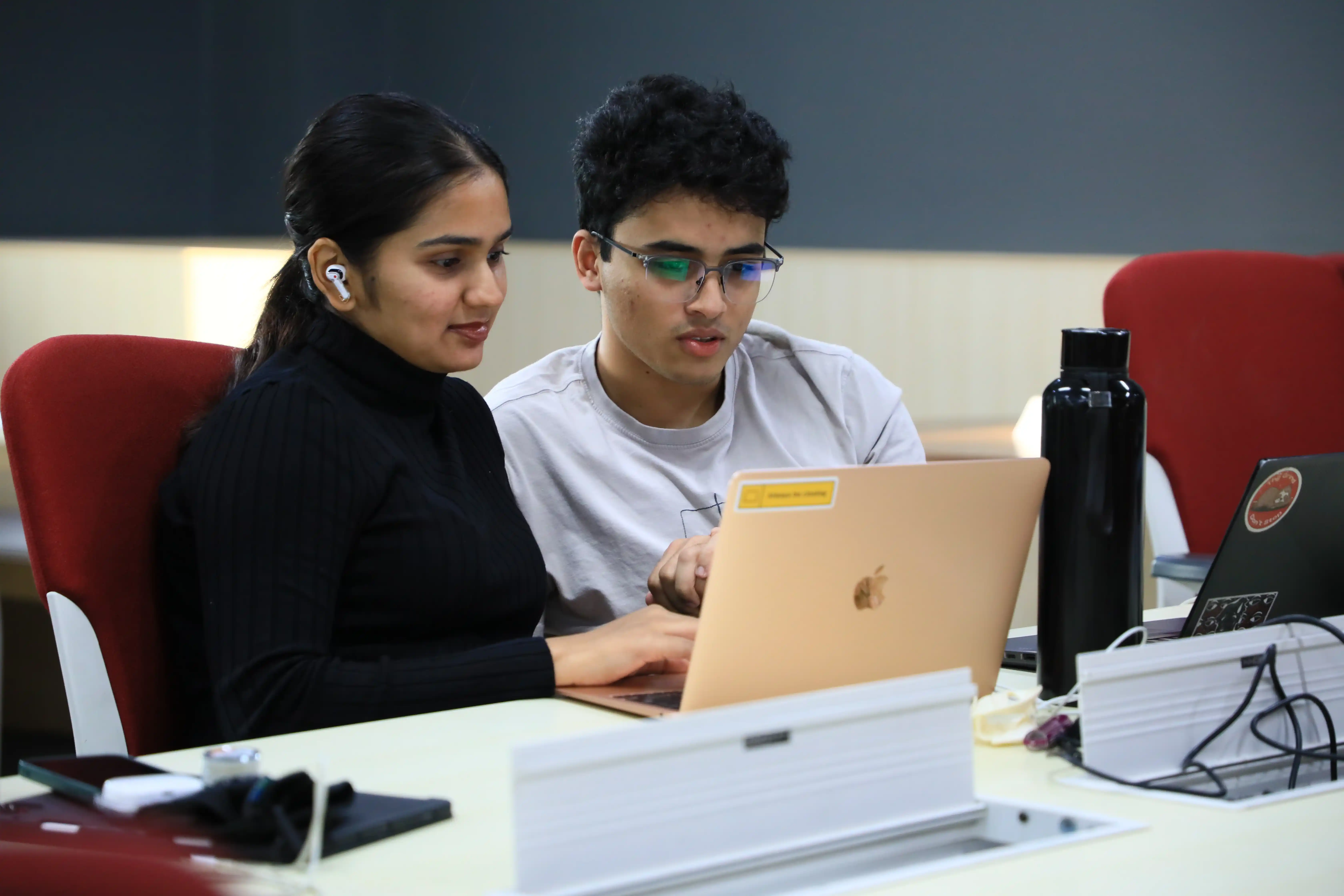 Students collaborating on a laptop in a computer science learning environment